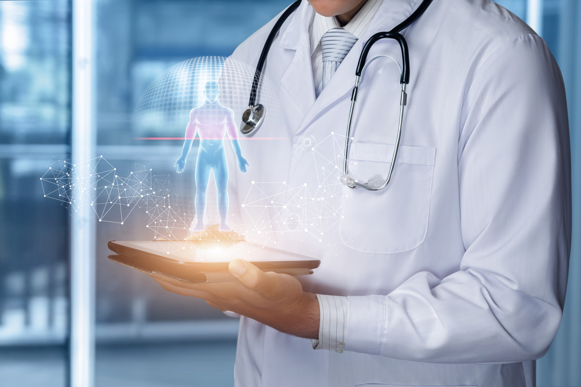 A doctor in a white coat holds a tablet displaying a holographic human figure with digital connections, symbolizing advanced medical technology and innovation.