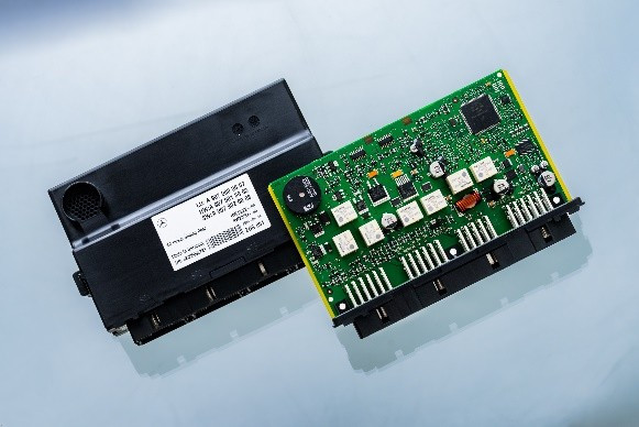 Eine elektronische Steuerplatine mit einer Vielzahl von Bauteilen, darunter Widerstände, Kondensatoren und Steckeranschlüsse, auf einem reflektierenden Untergrund.