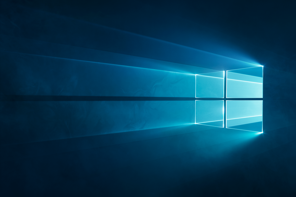 A glowing blue background with light beams creating a window-like shape in the center, reminiscent of the Windows logo.